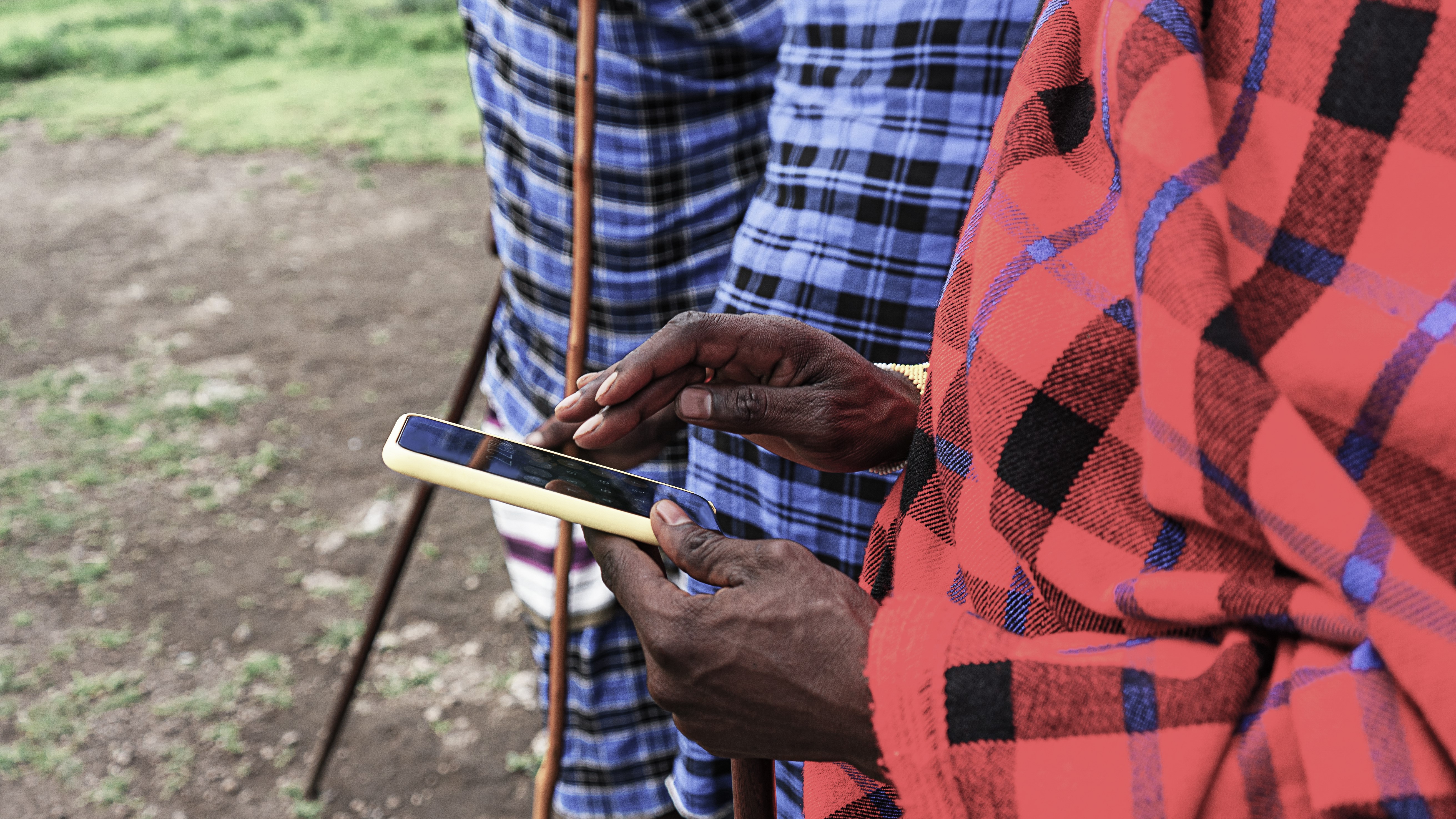 African man in traditional clothing with a smartphone