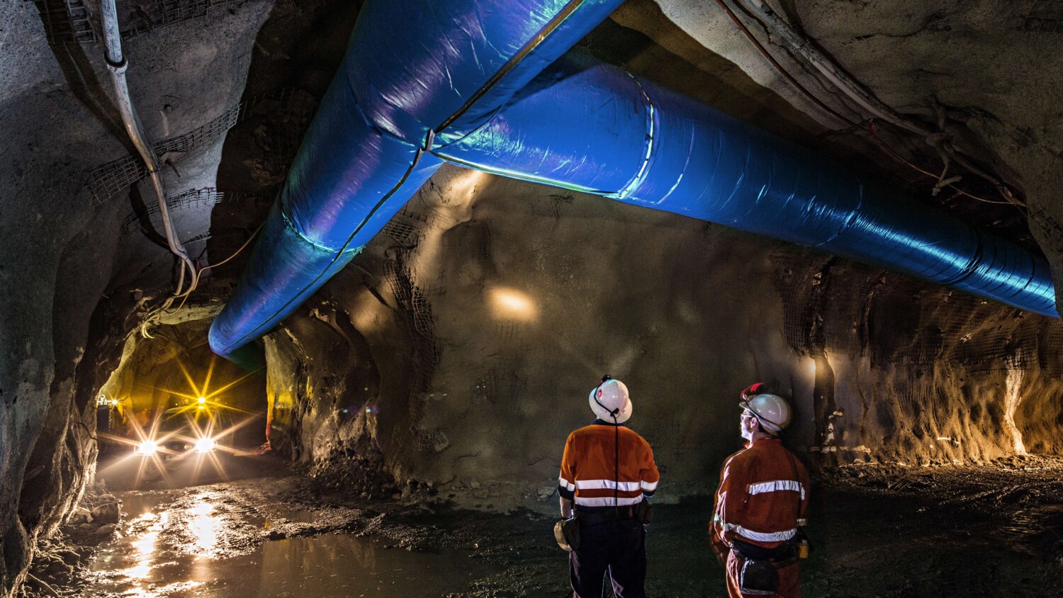 Miners inspecting an underground ventilation system in a gold mine