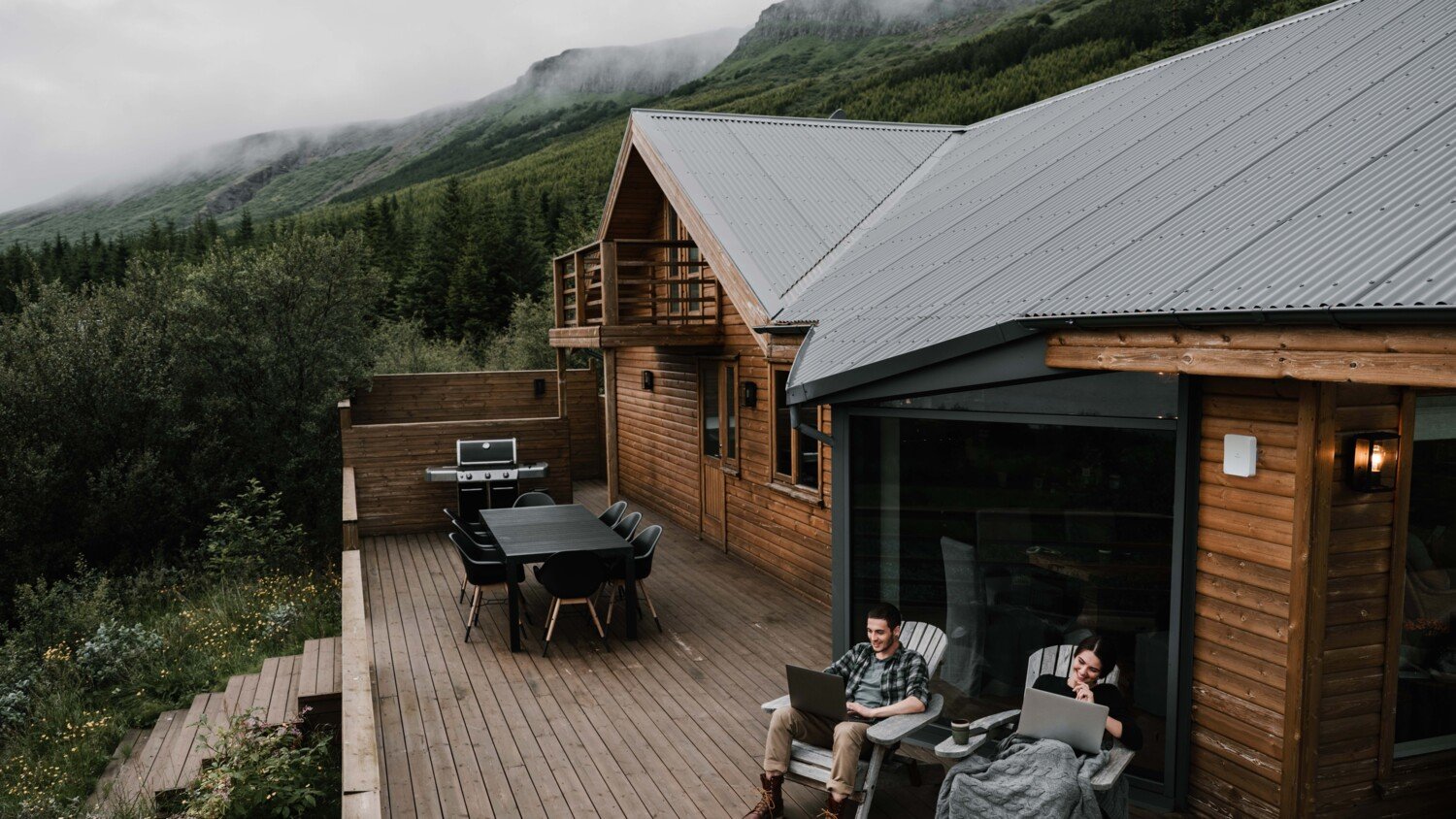 Couple working online from mountain cabin