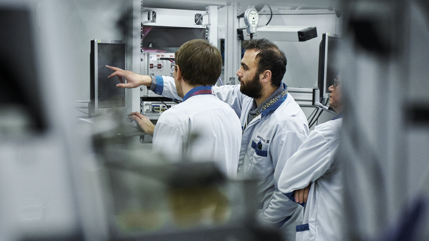 Engineers in factory looking at screens