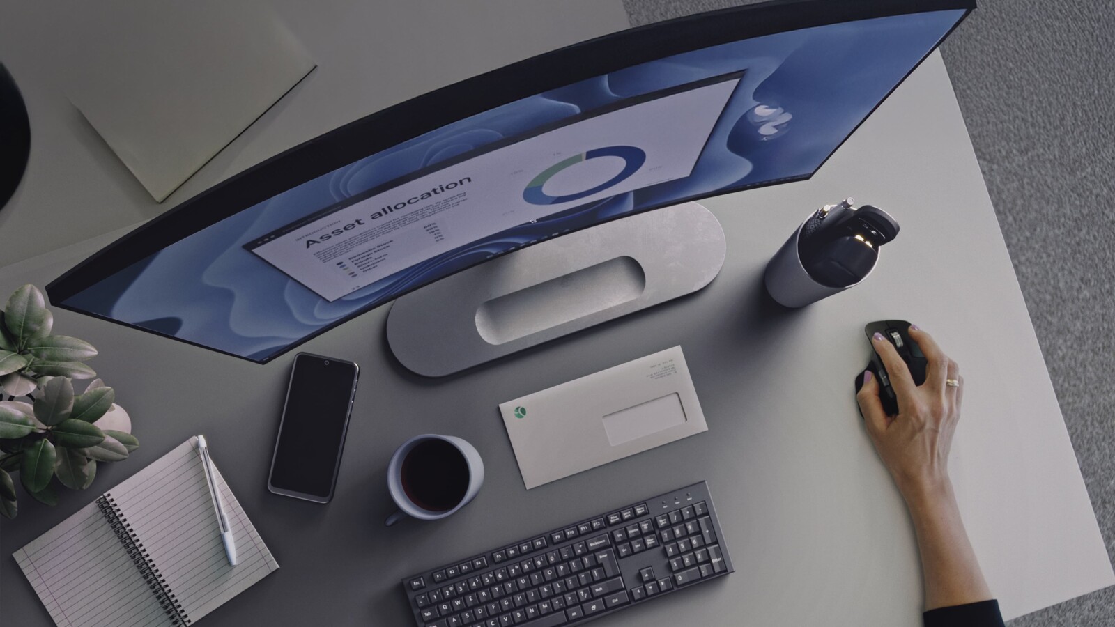 工作區有顯示器上的圖表、筆記本和咖啡。