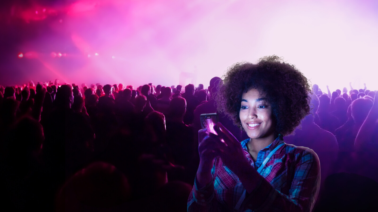 Woman using her phone in a concert.
