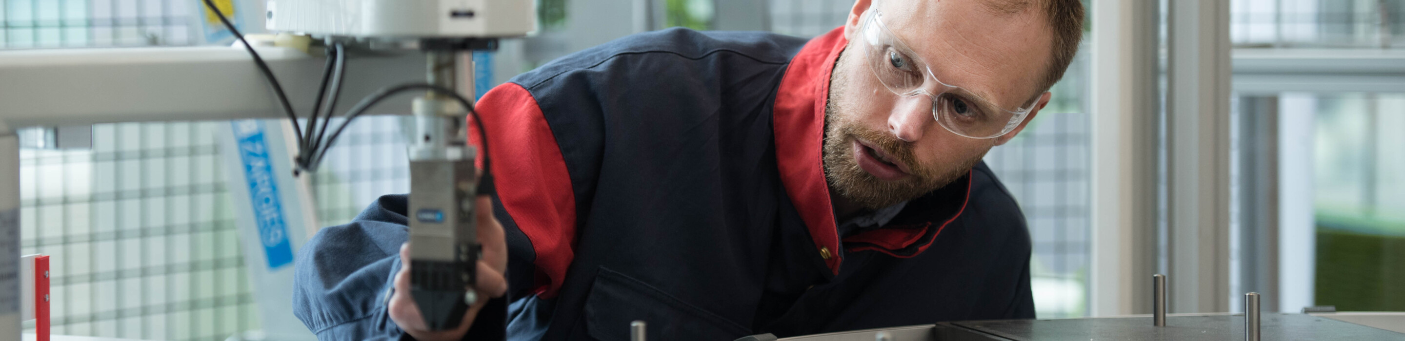 Factory worker adjusting a sensor in one of the Industry 4.0 companies.