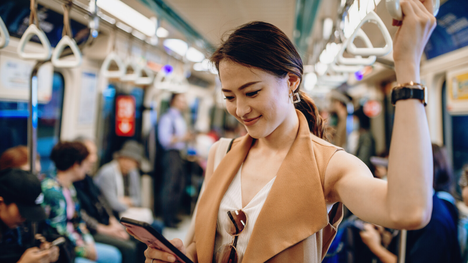 Woman checking her phone on the subway. 
