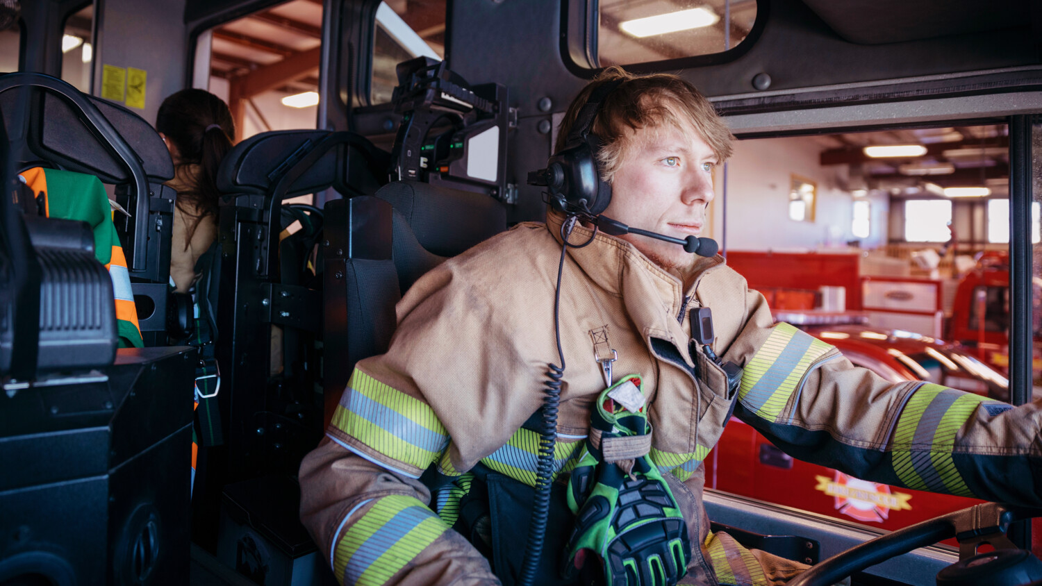 Fireman driving with a head set on.