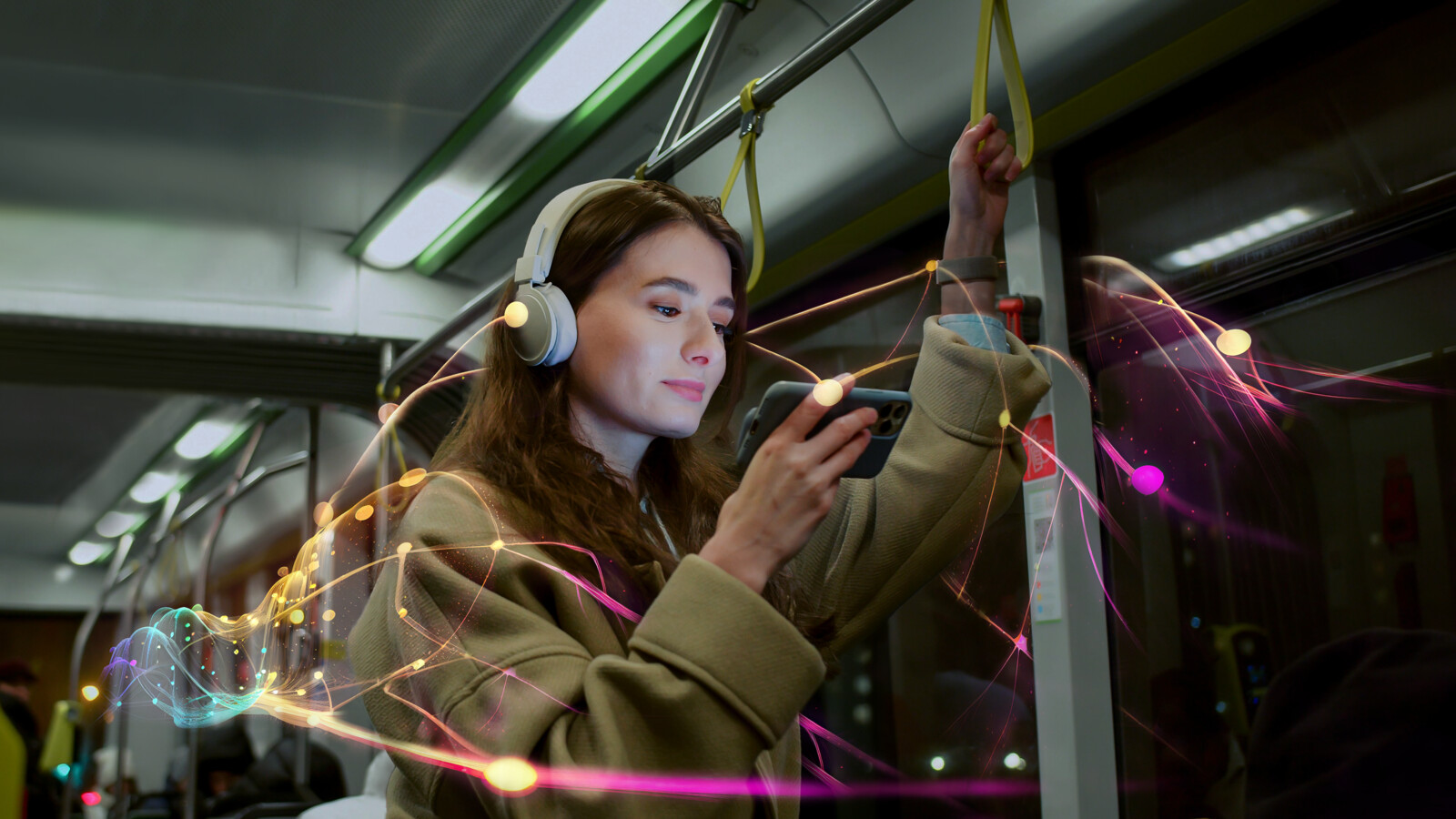Person with headphones watching mobile phone on bus.