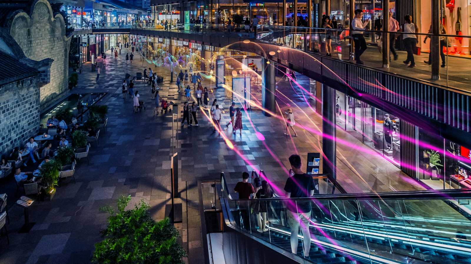 Shopping area by night with colorful lights.