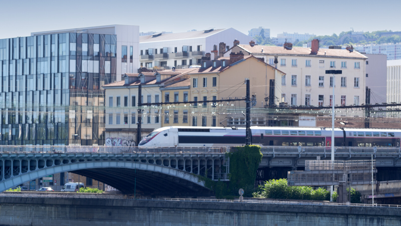 Modern white train on bridge European city