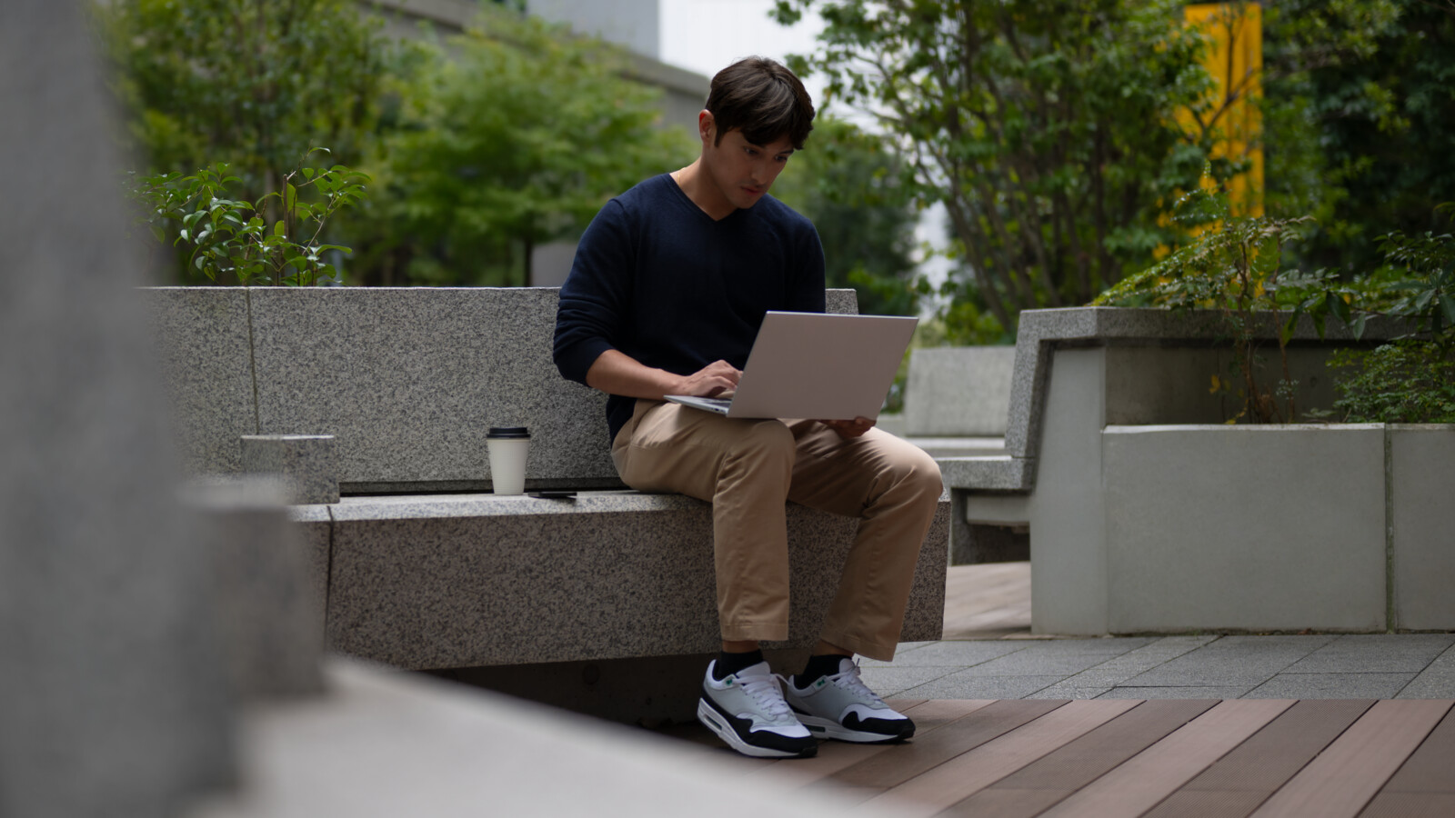 A developer working on a laptop outdoors.