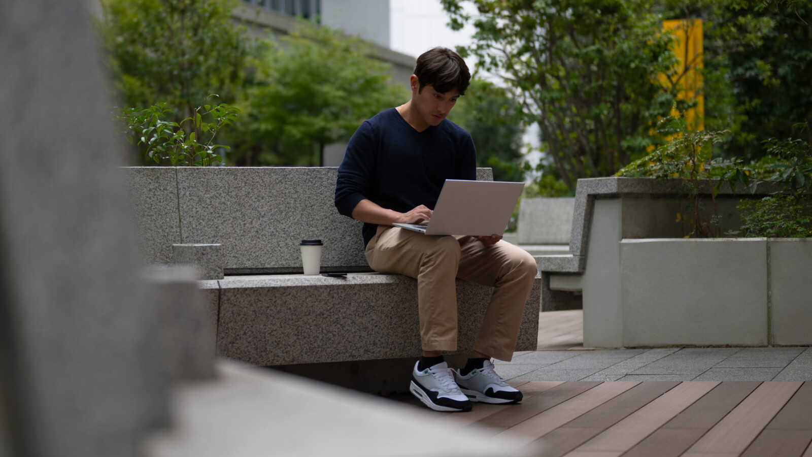 A developer working on a laptop outdoors.