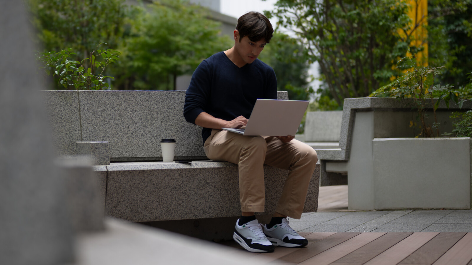 A developer working on a laptop outdoors.