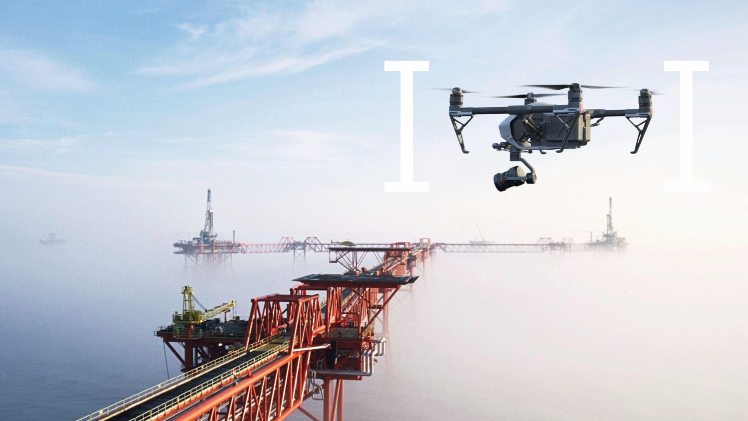 A drone flying over an off shore oil rig.