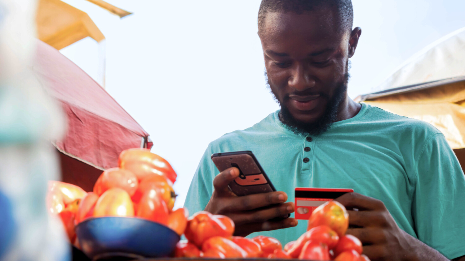 Young man using credit card in market