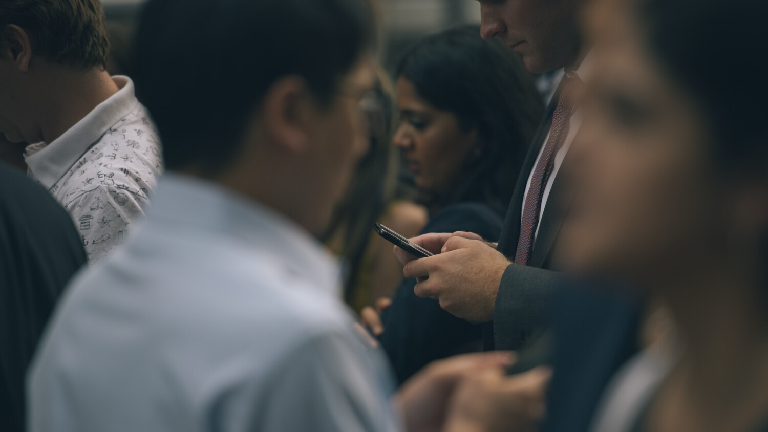 Man looking at the smartphone in a crowded transport