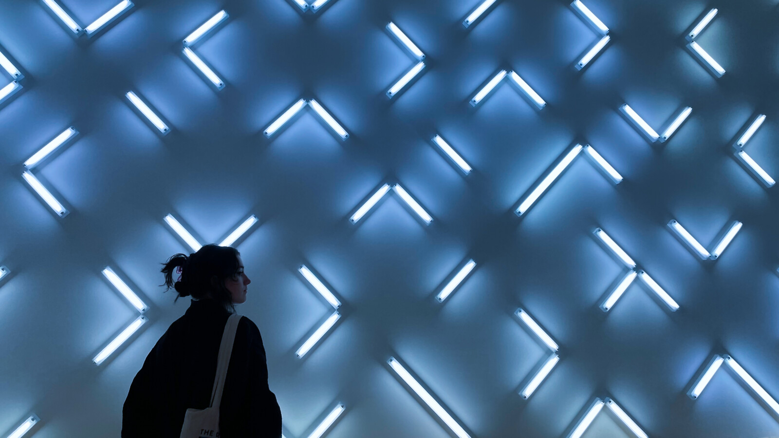 Person in front of light installed background.