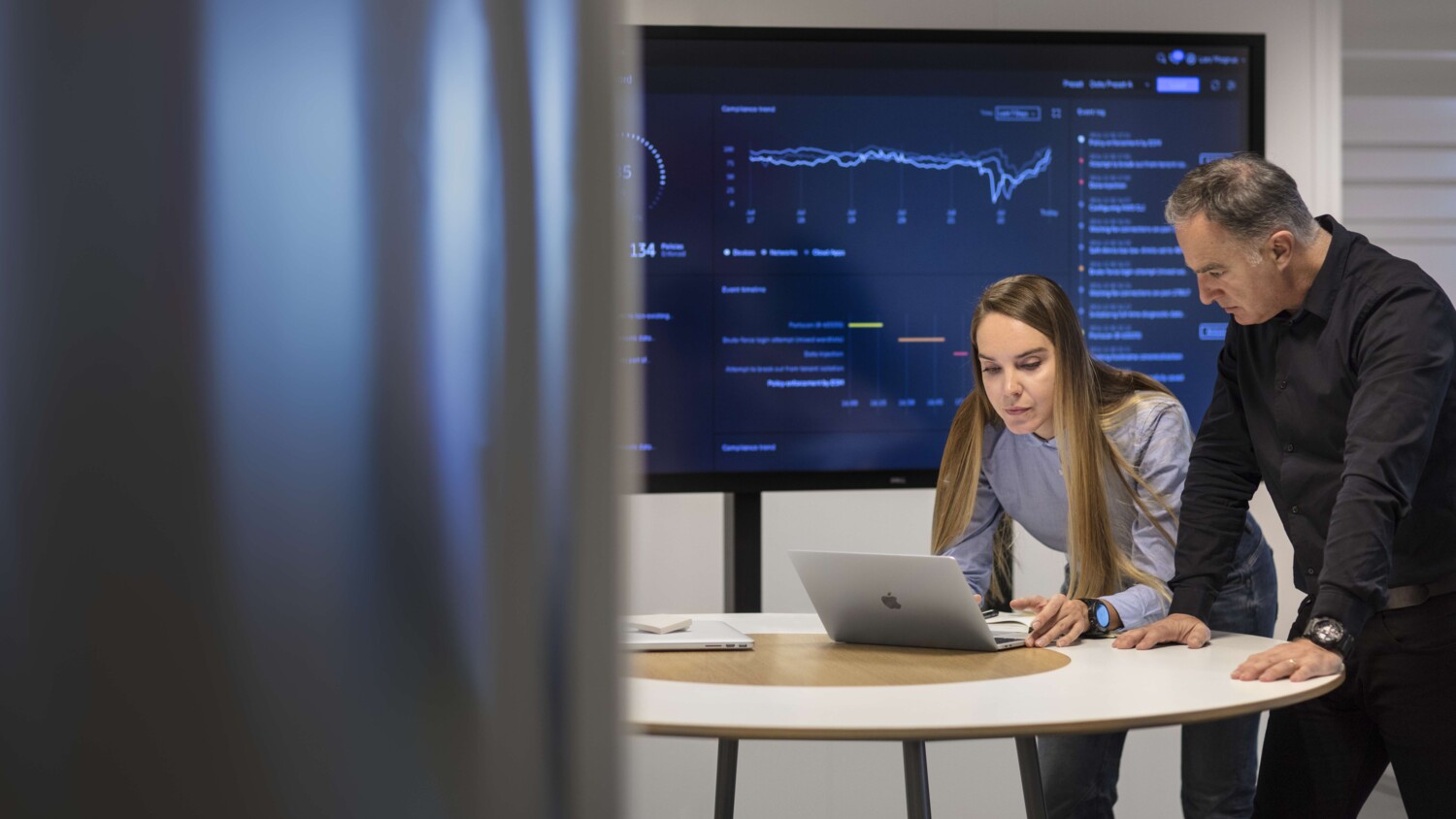 Colleagues with laptop, collaborating.