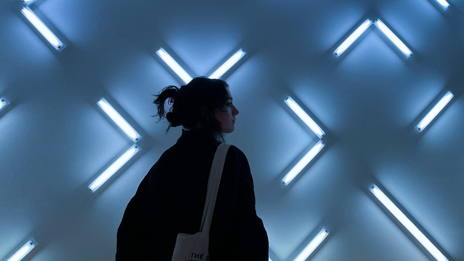 A woman posing in a spectacular light installed background