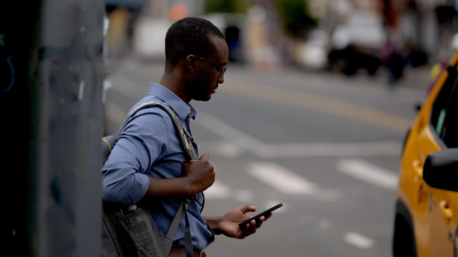 A man checking his phone on the street.
