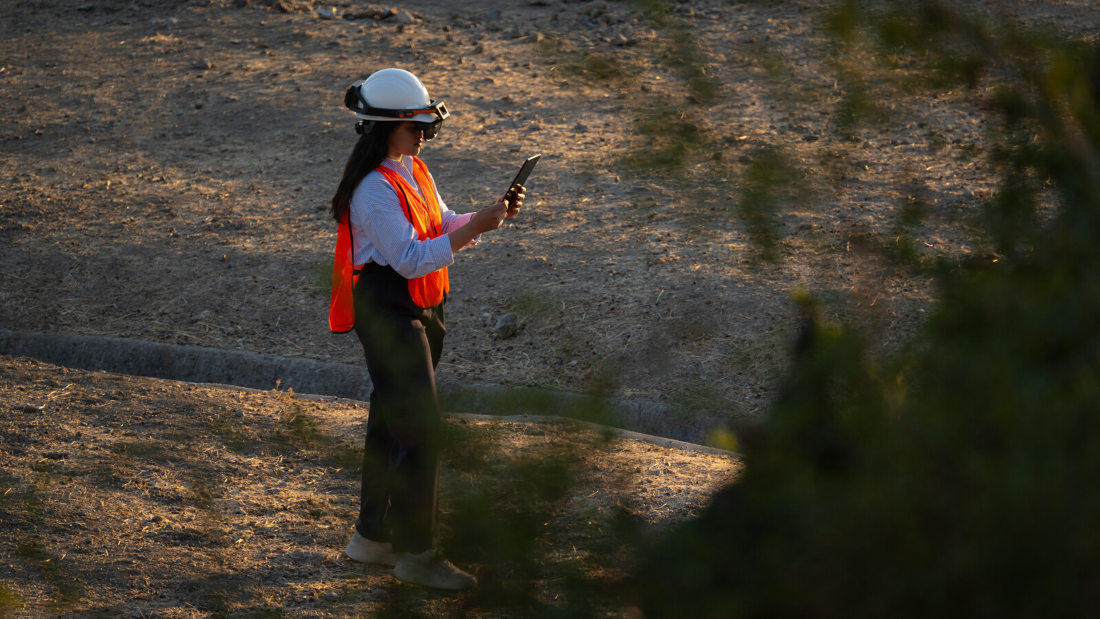 Woman working on laptop in rural area.