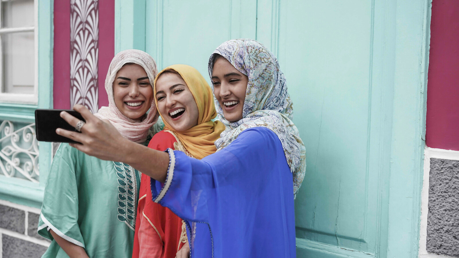 Happy friends using smartphone.