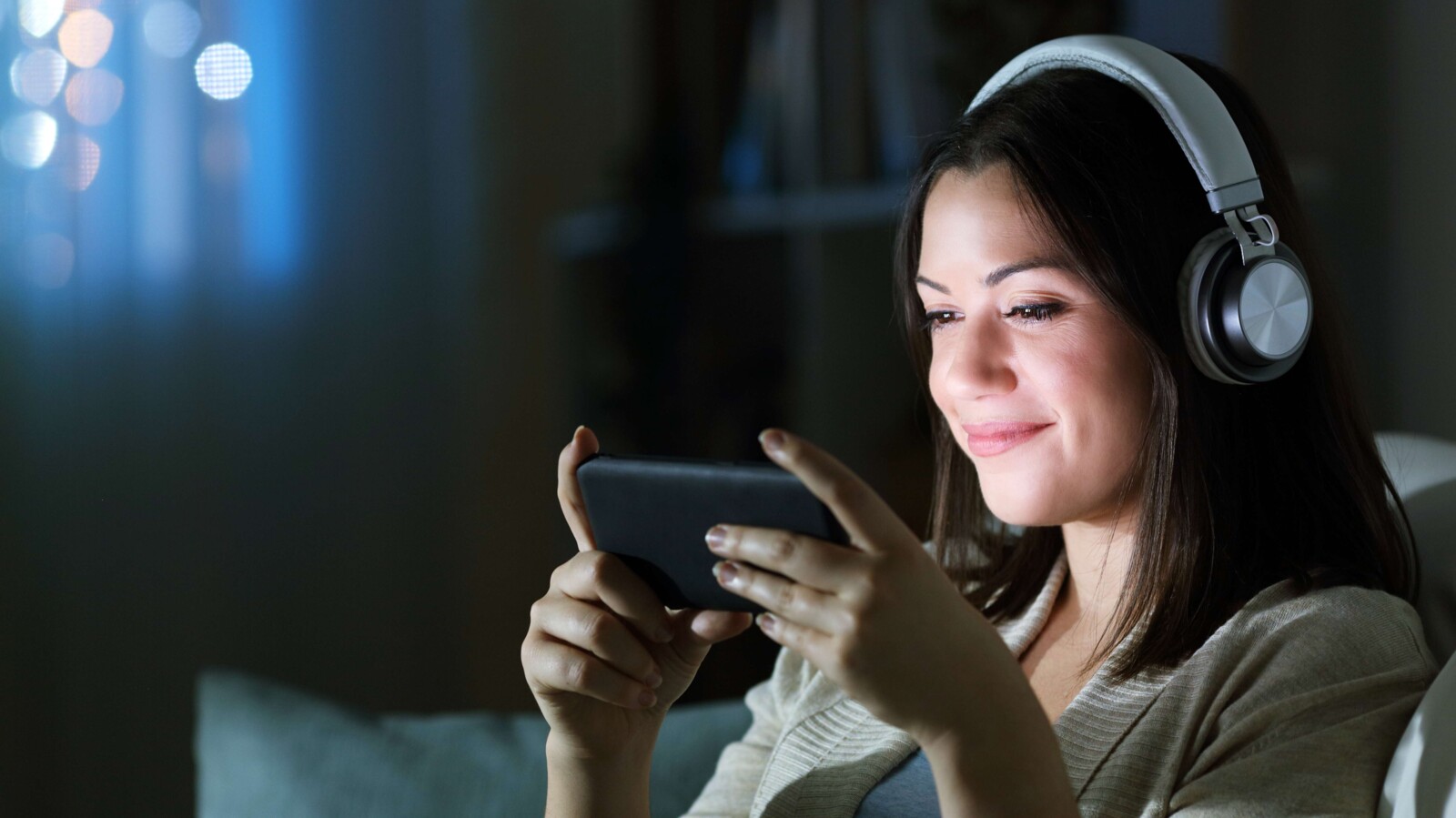 Woman with headphones watching video on smart phone