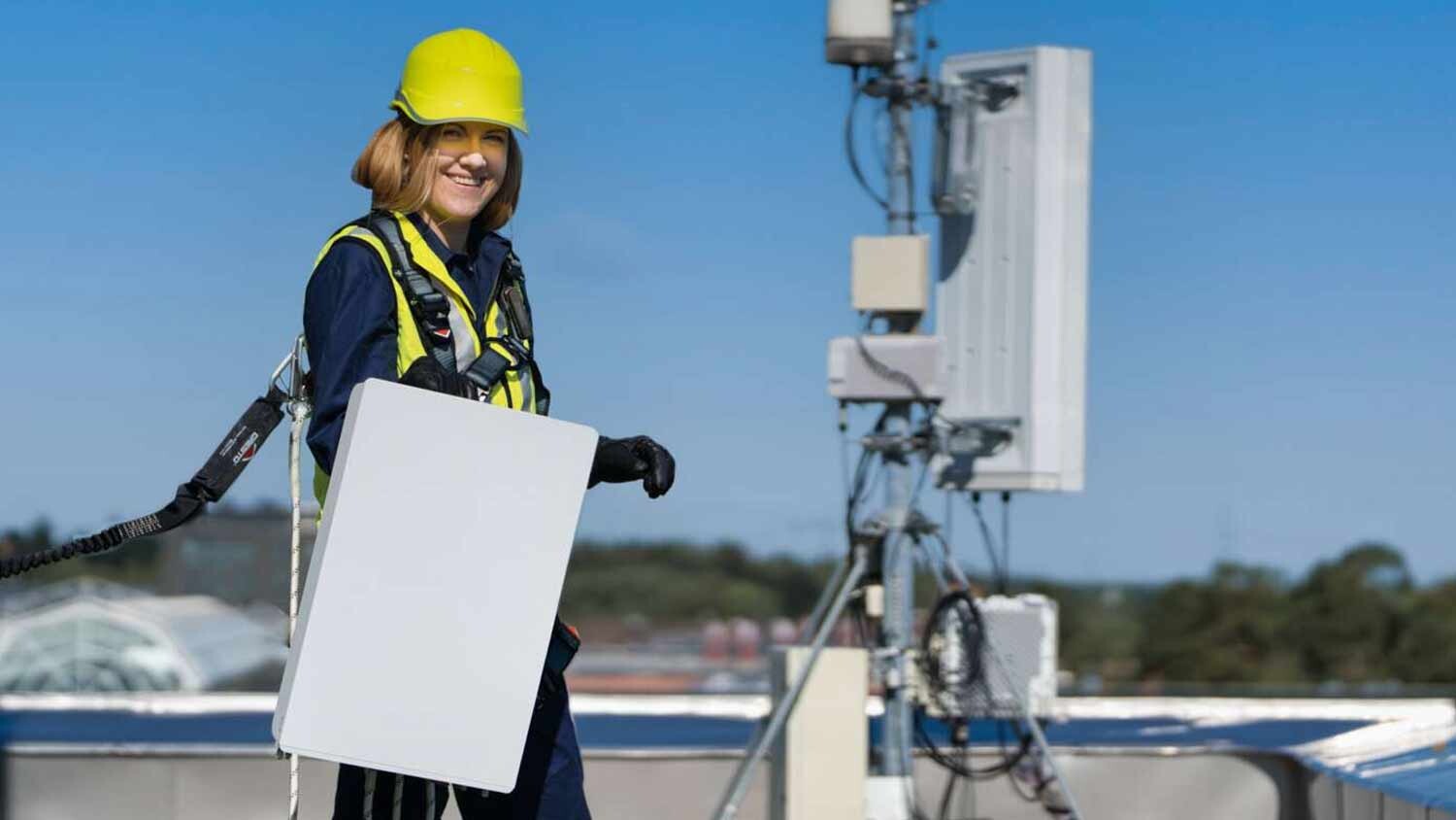 Field technician on a rooftop with a radio mast.