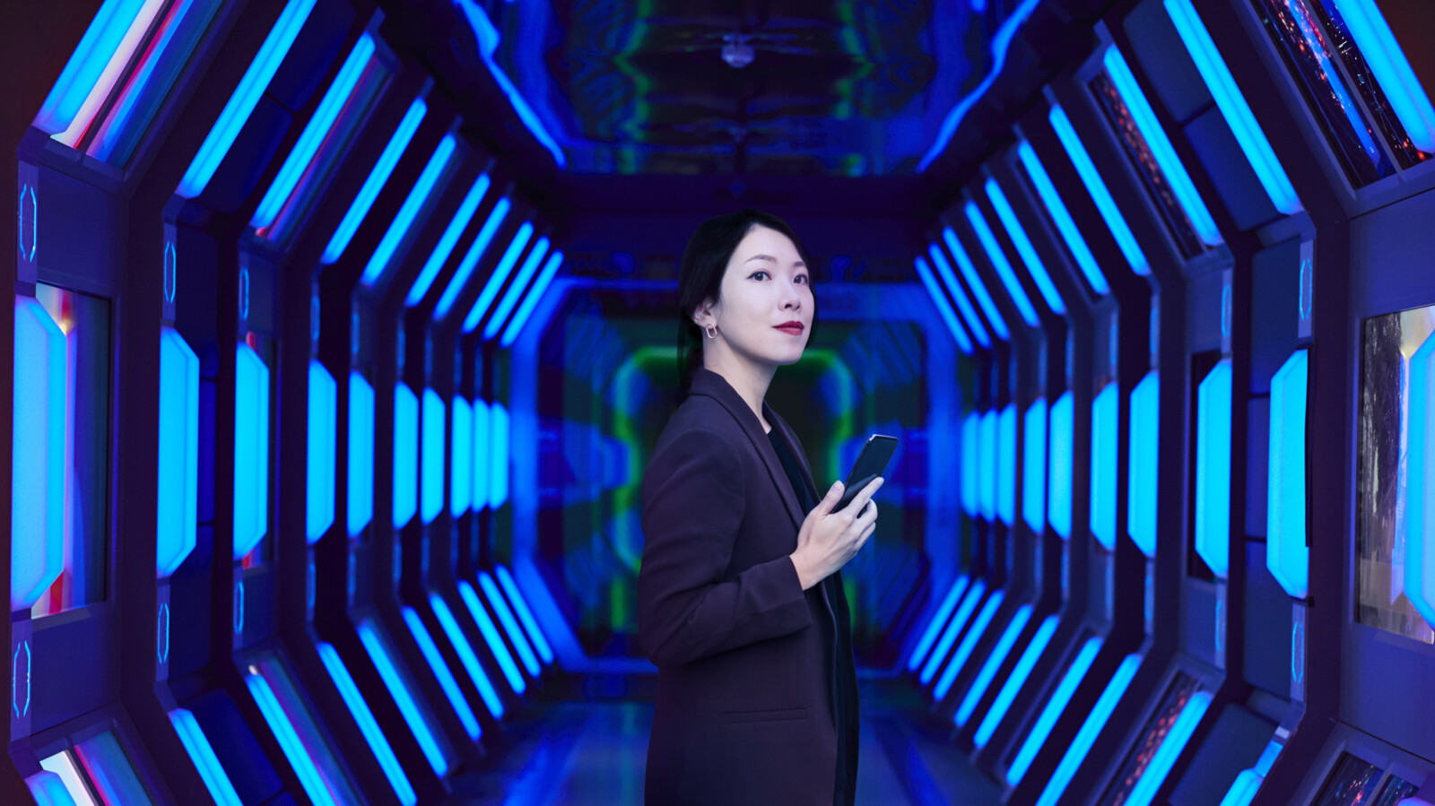 Woman with a phone in a neon lit room.