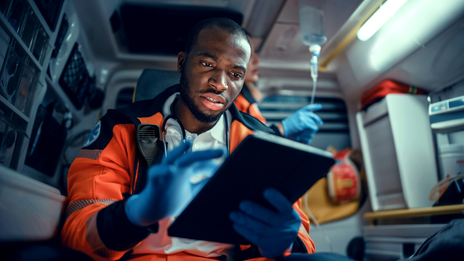 Medical staff with tablet in an ambulance.