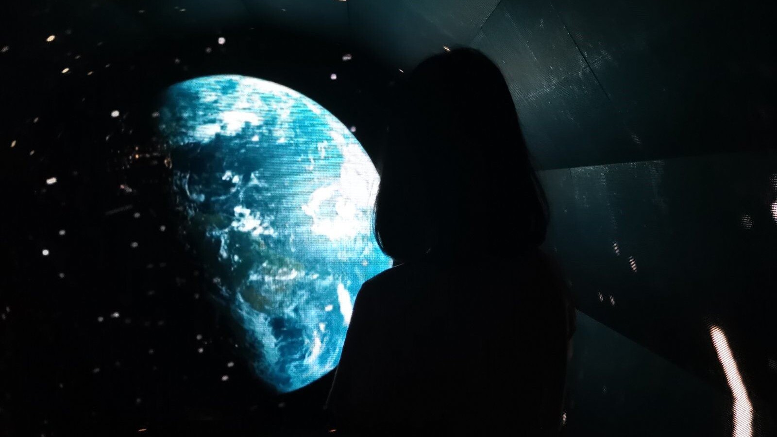 A girl looking at the planet in the dark sky