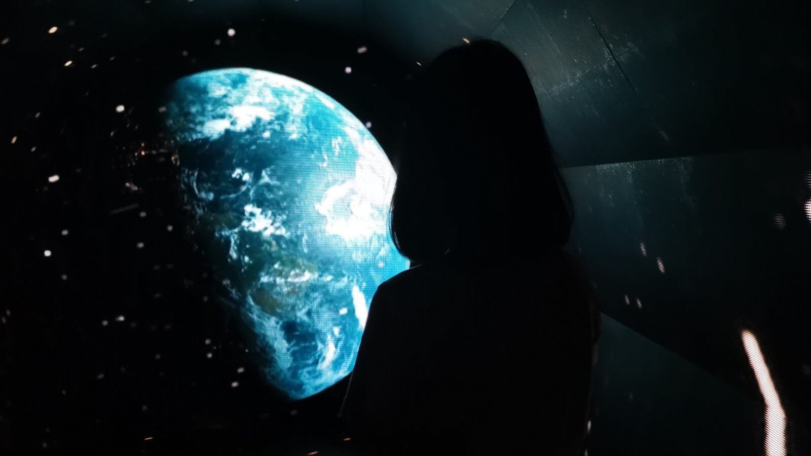 A person looking at the image of earth