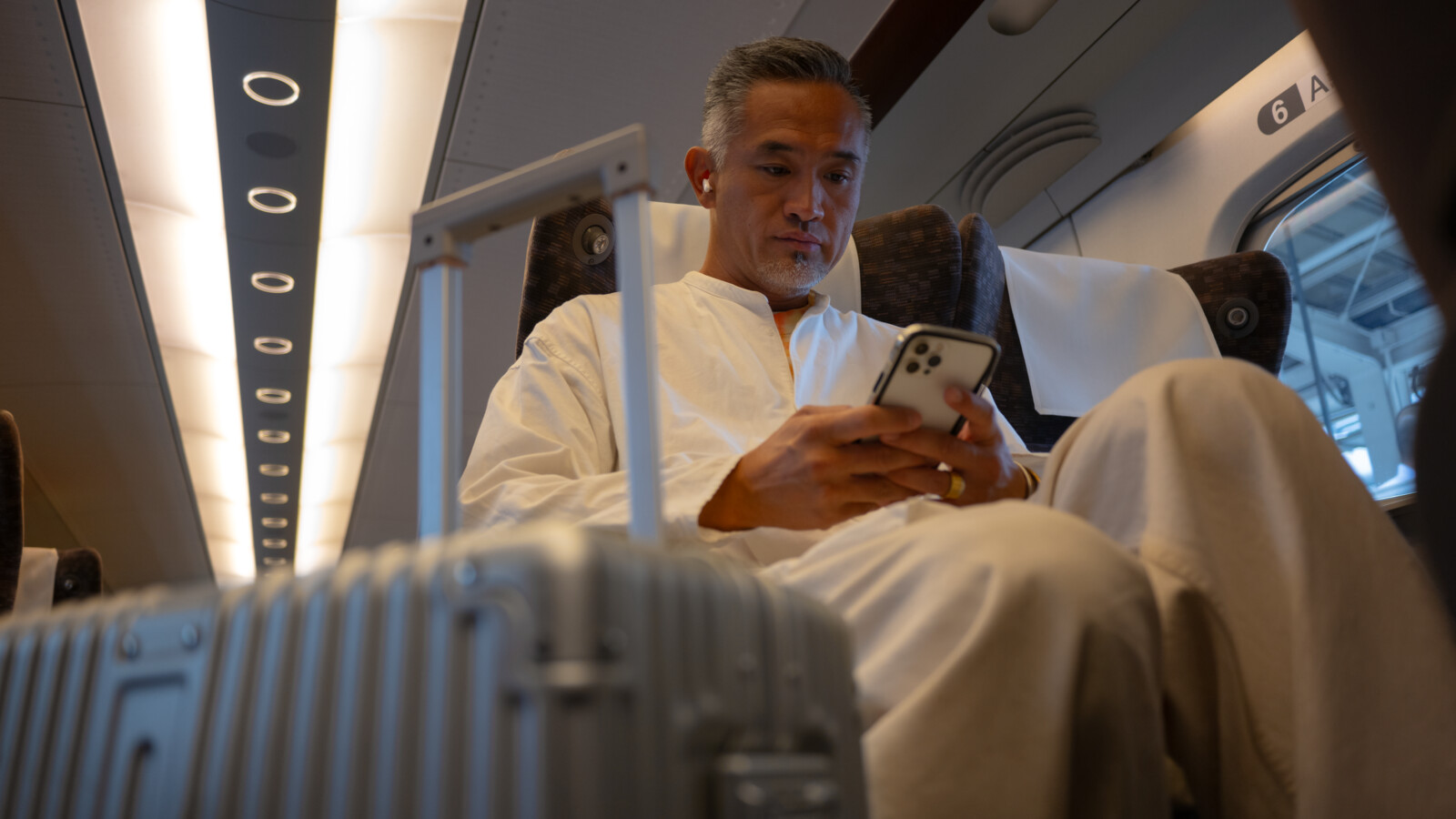 A man checking his mobile phone on a train