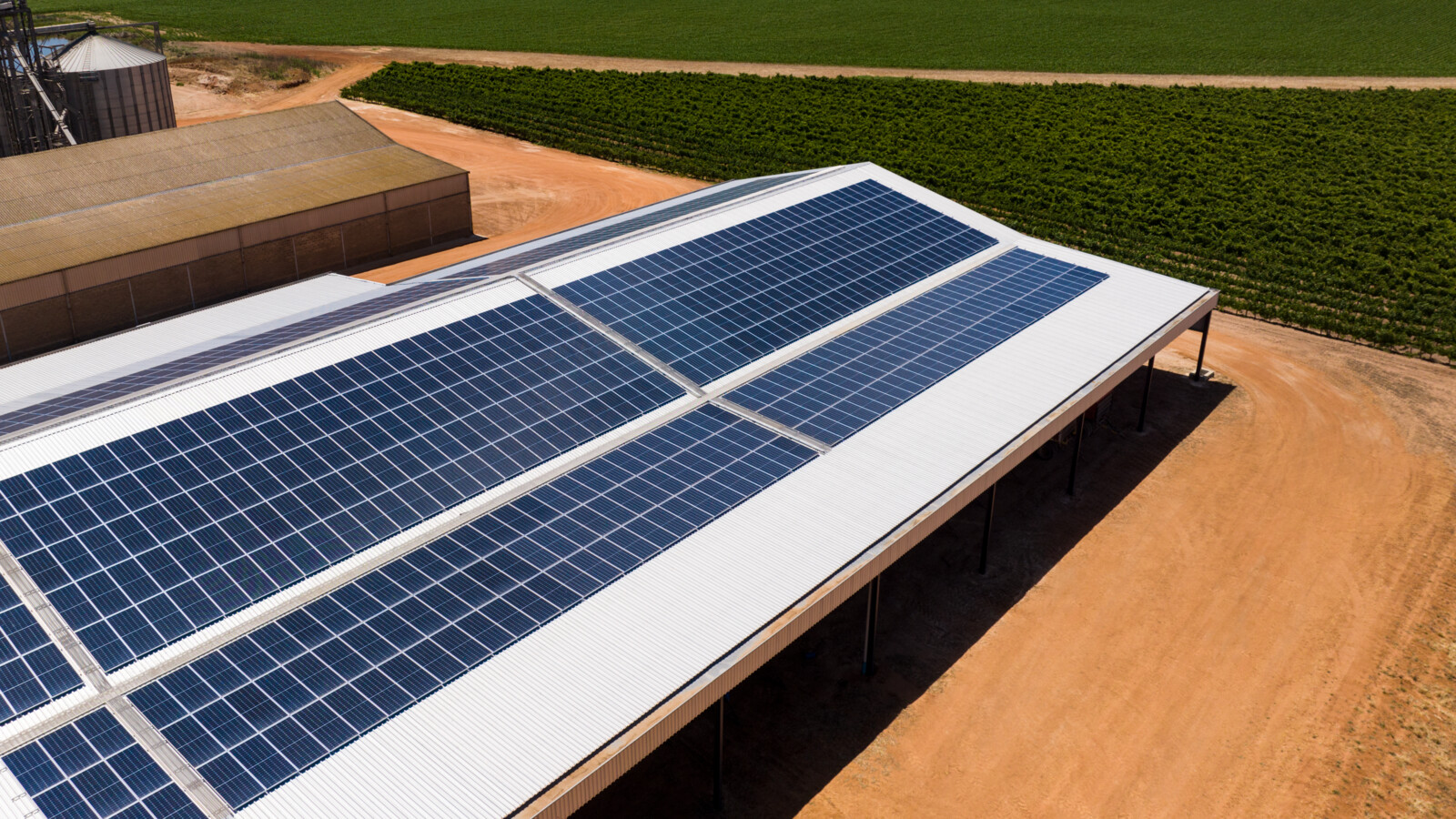 Solar panels at a farm next to fields.