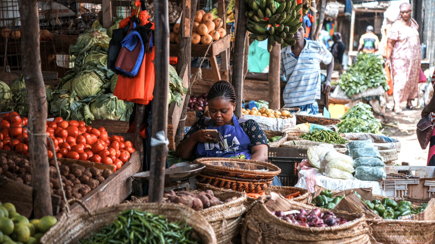 Woman working at local market looking in her mobile phone..