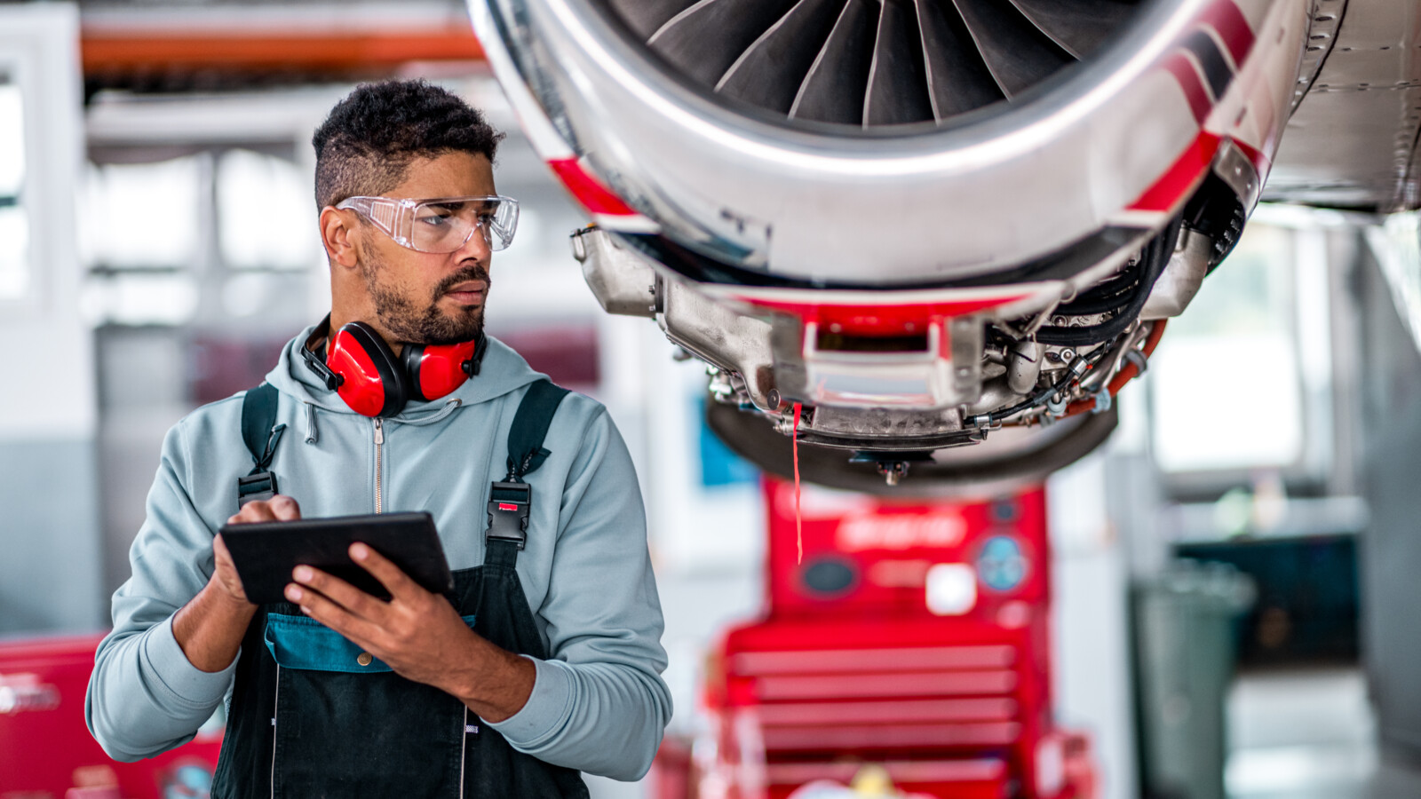 technician holds a tablet to assist with aircraft maintenance