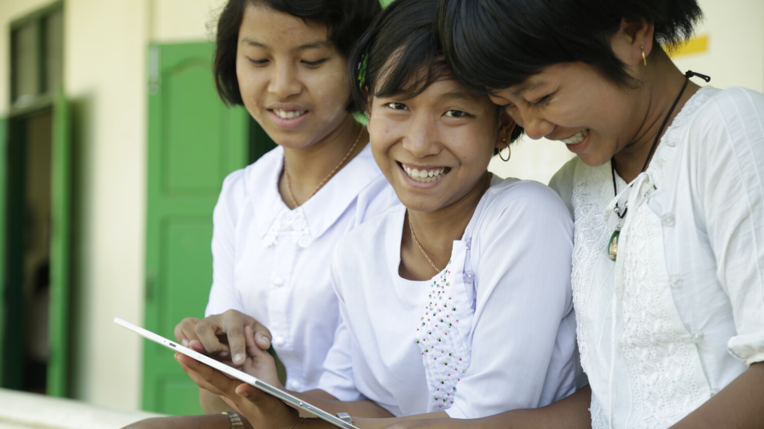 Three girls looking at their tablets