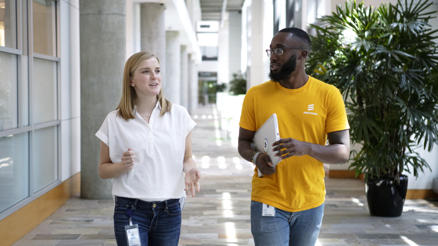 A woman and a man walking through a corridor