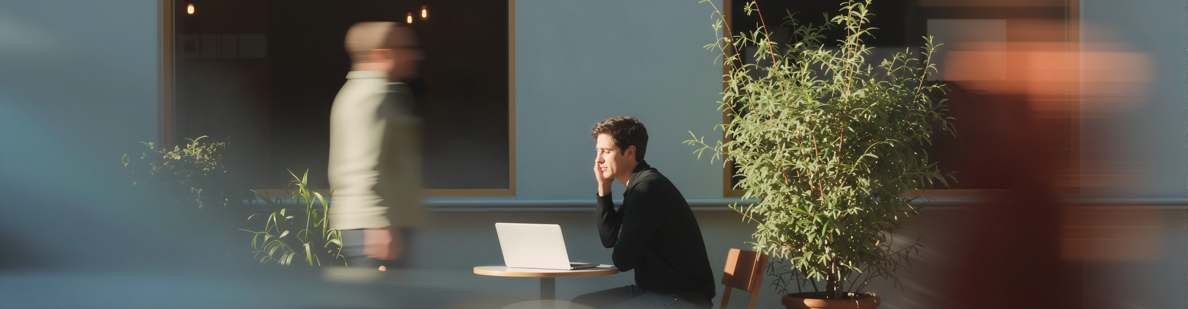 Man working on laptop outside café