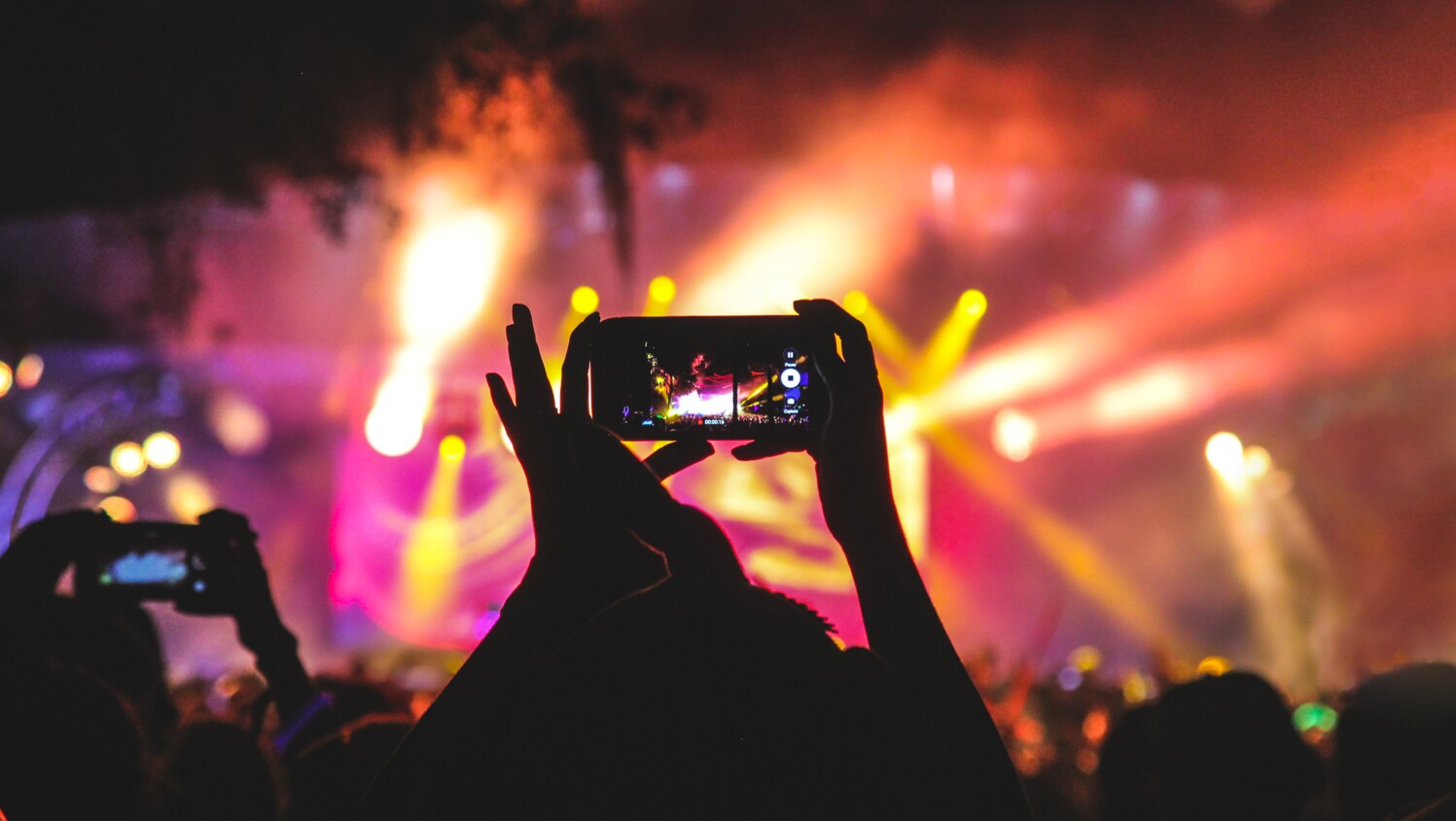 Taking a photo with mobile in a concert.