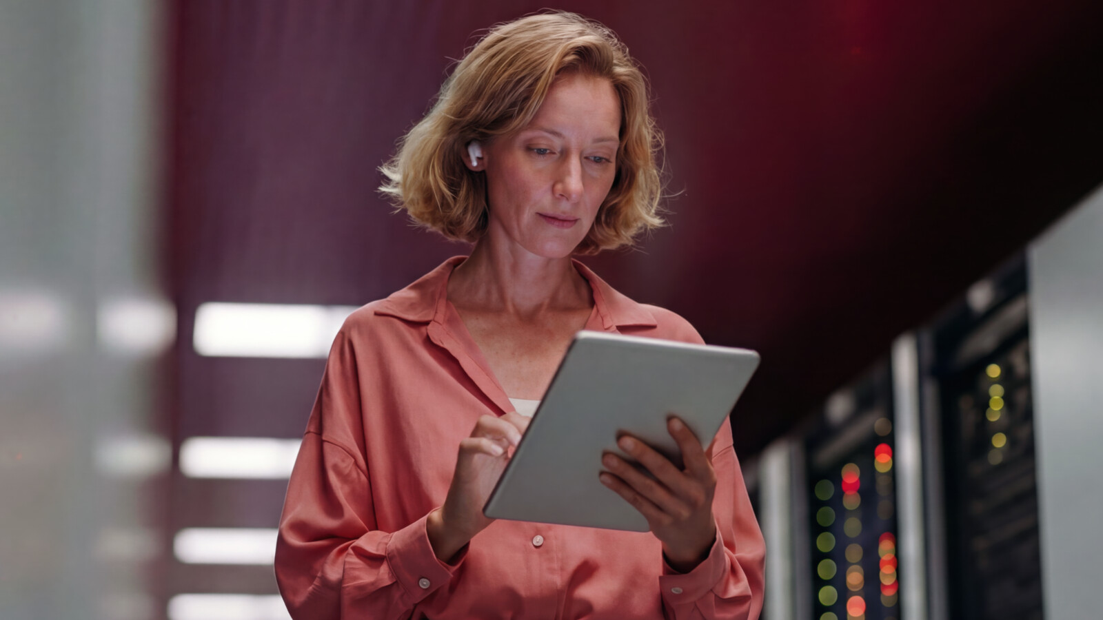 Woman using tablet while standing in data center corridor