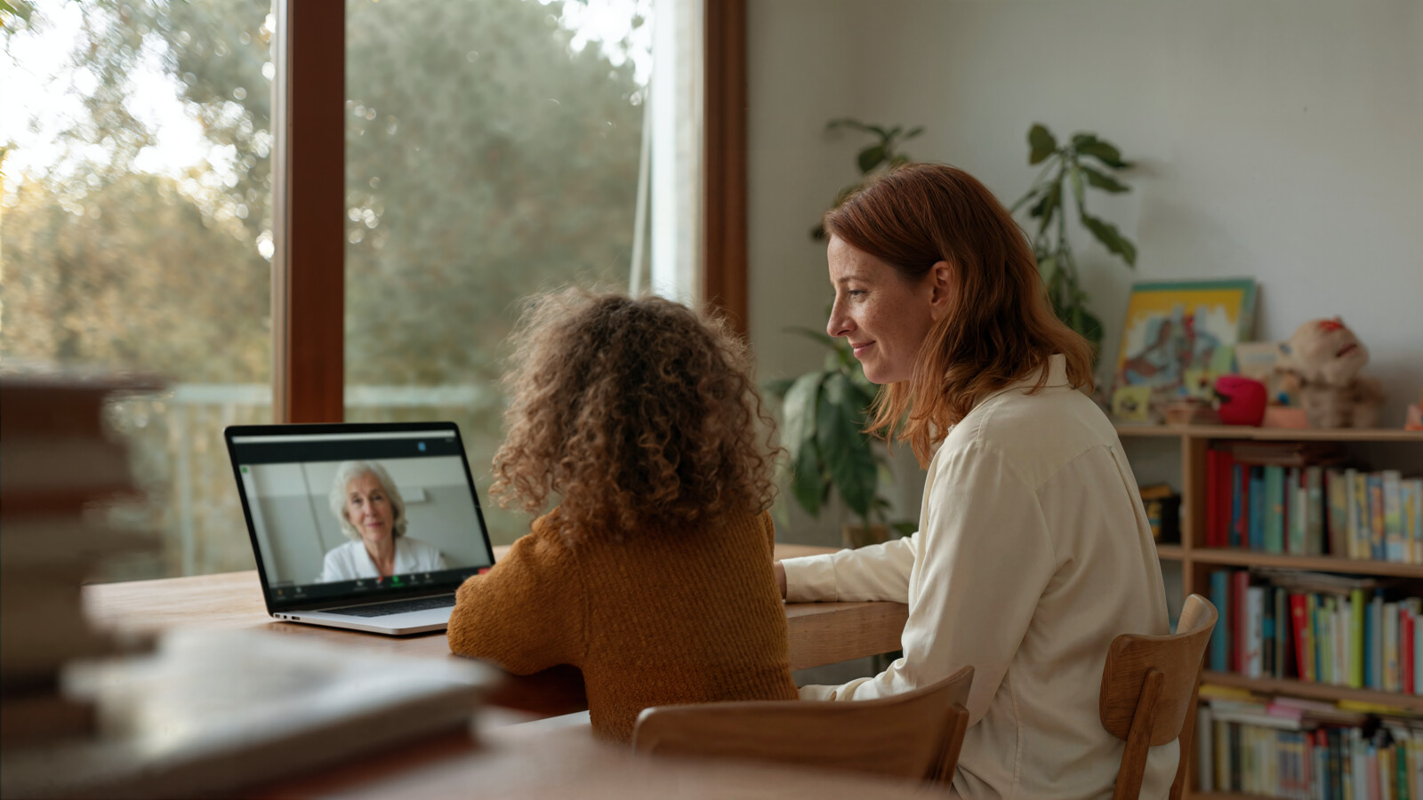 Mother and child having video call with doctor on laptop at home