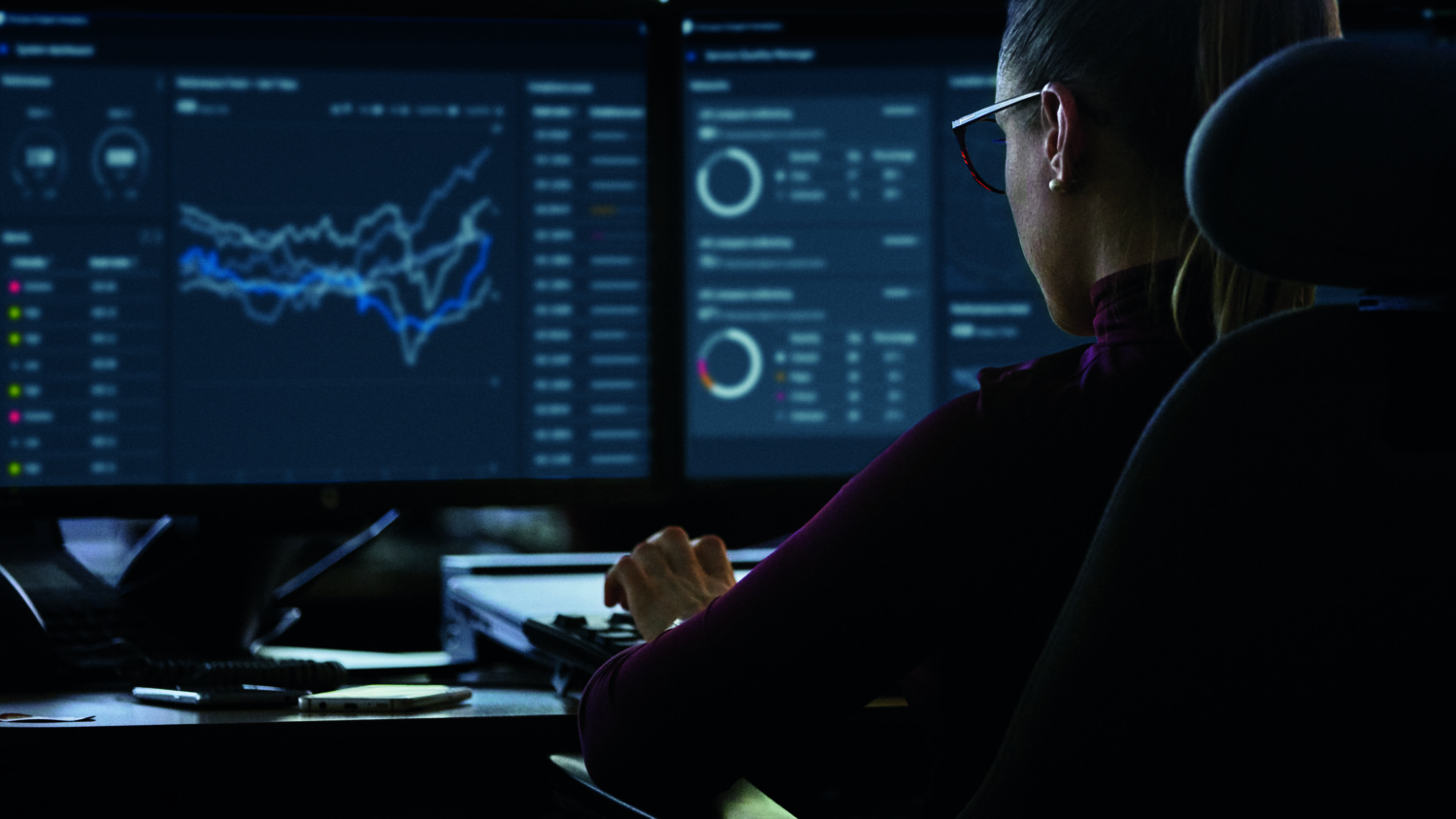 A woman working at a network terminal overseeing operations. 