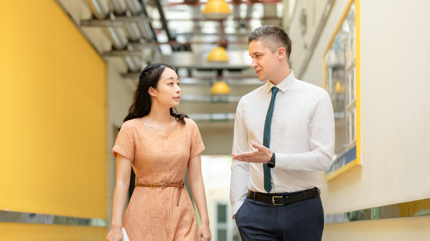 man and woman walking in a hallway
