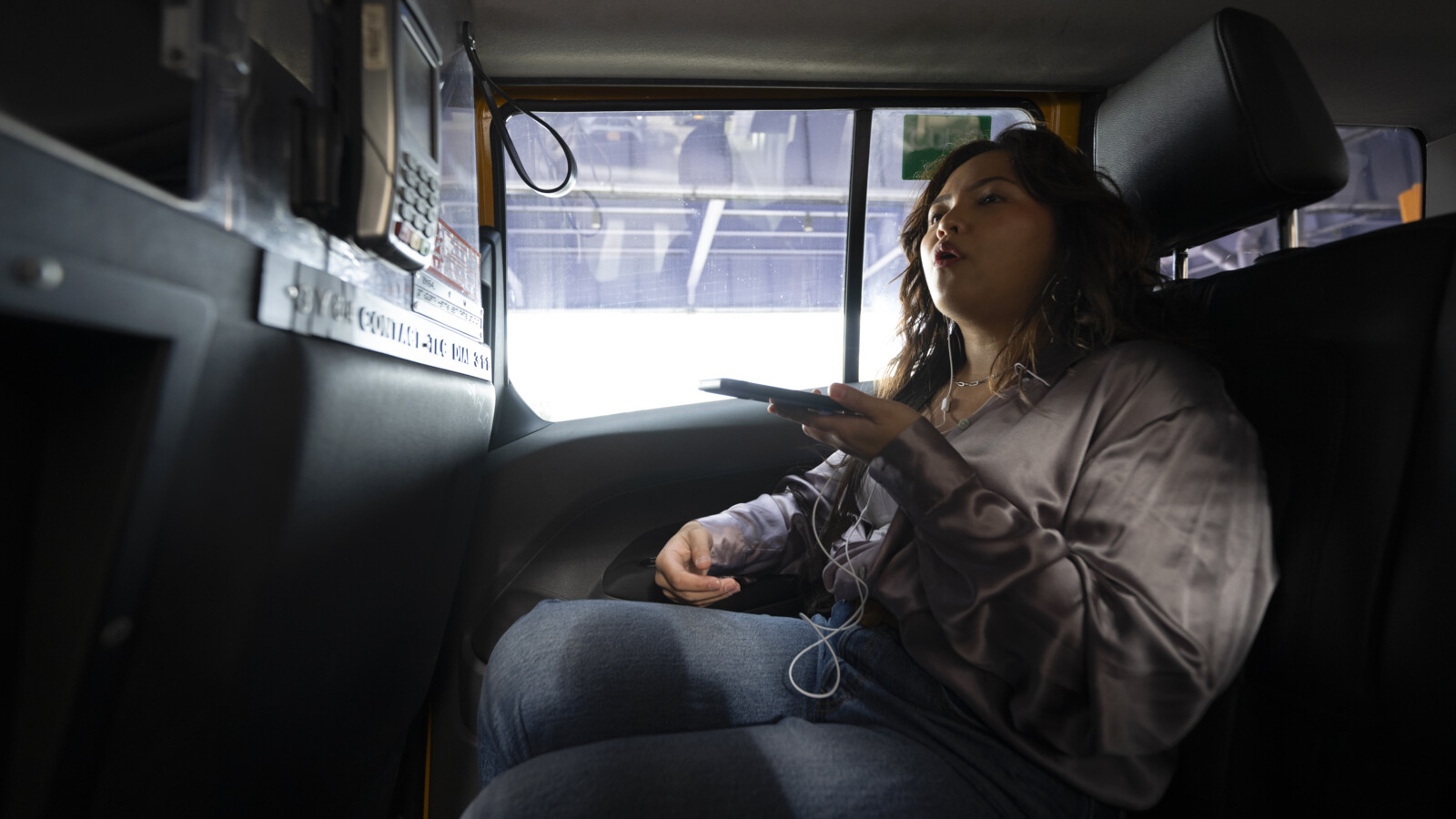 A woman inside a car making a voice call