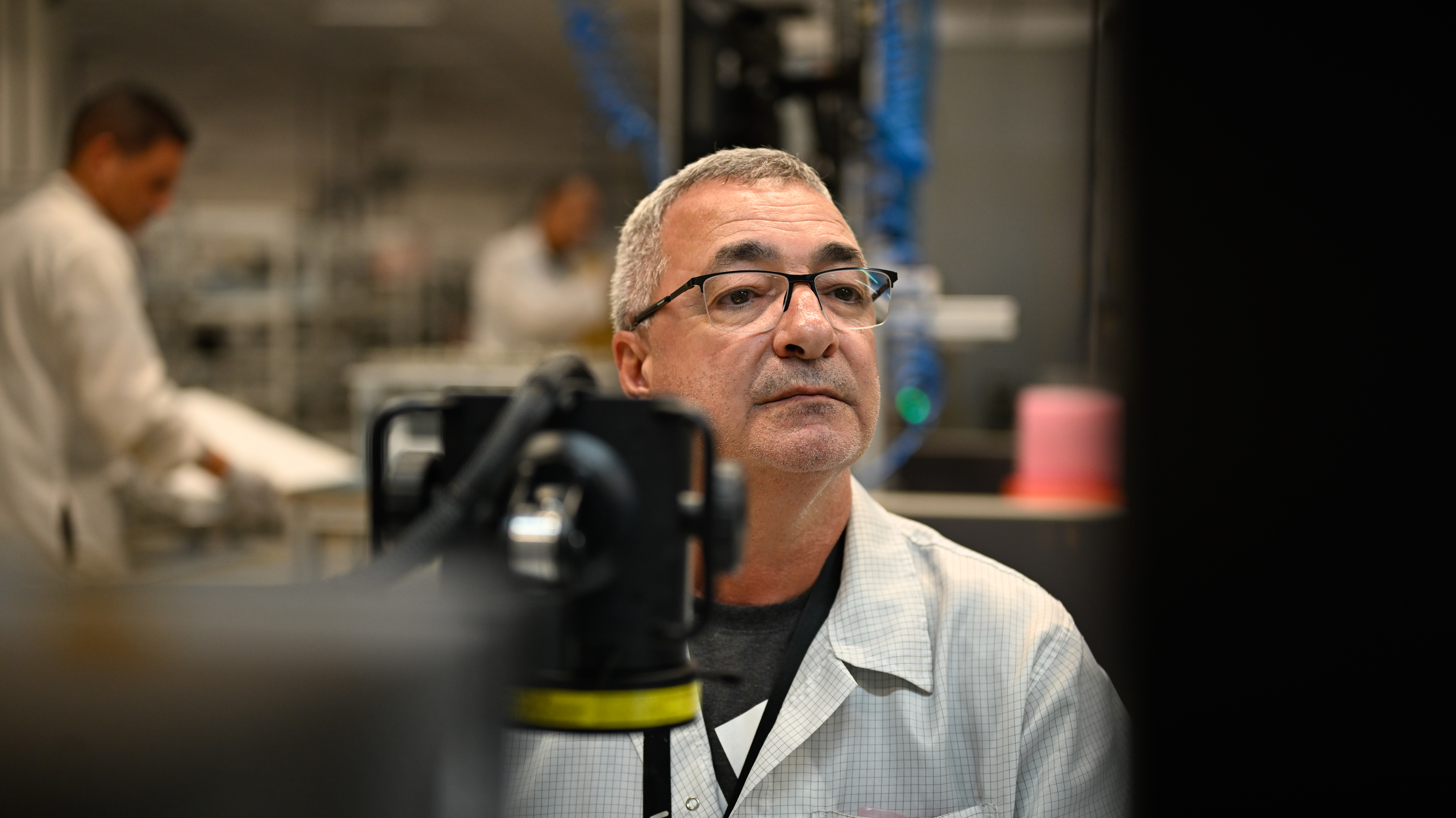 Ericsson employee/ researcher working in a lab with unwavering focus.