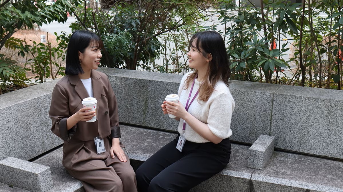2 Ericsson Japan women employees looking at each other smiling