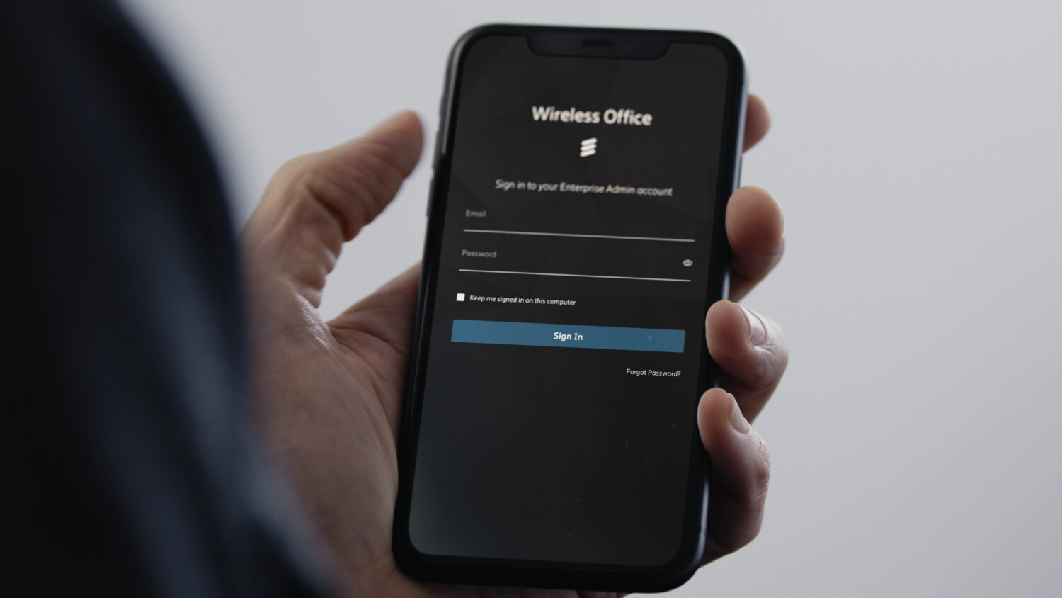 A hand with mobile phone that says Wireless Office.