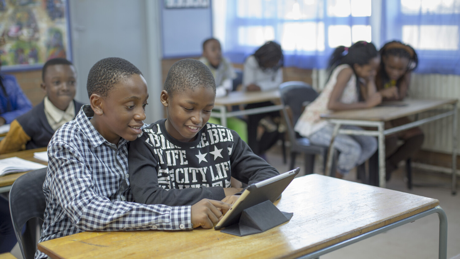 kids in a classroom looking at a device