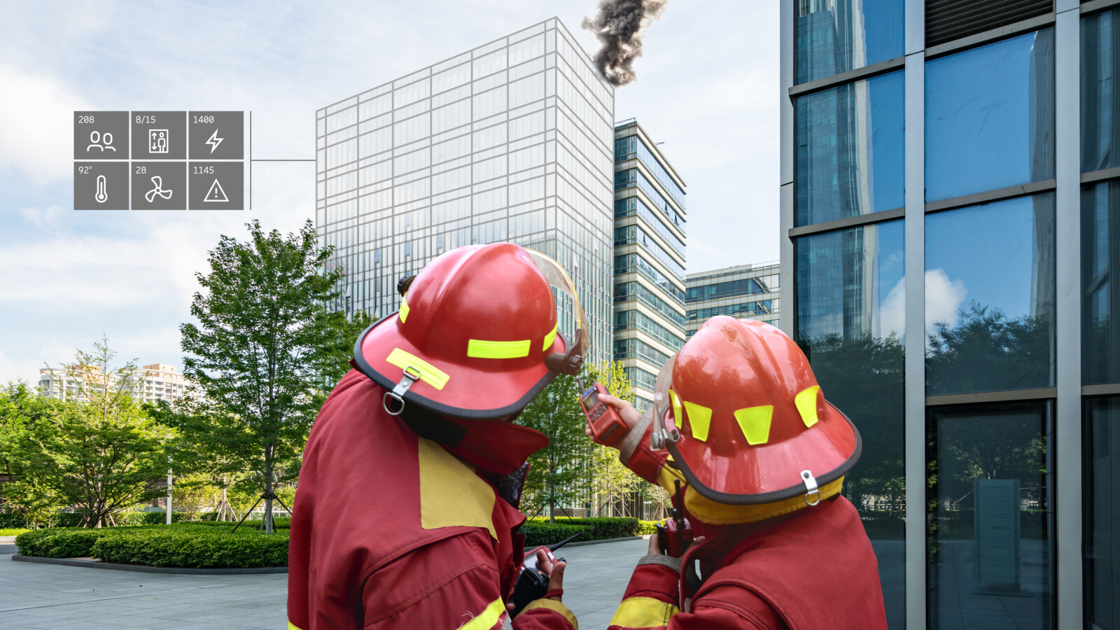 Firefighters outside building with smoke and overlay icons on the left representing emergency services.