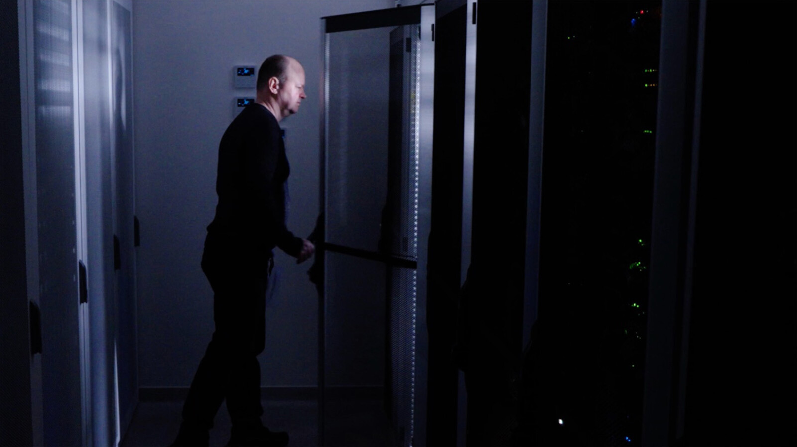 Man opening the door of a server rack
