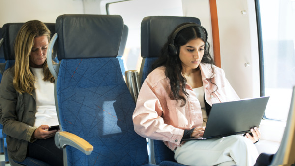 5G connectivity on train - woman working on her laptop 